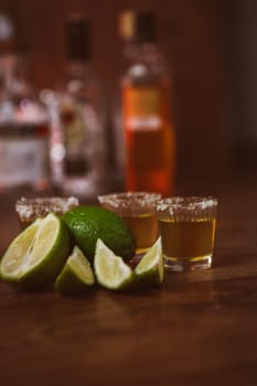tequila , lime and salt on wooden table selective focus
