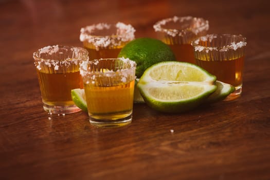tequila , lime and salt on wooden table selective focus
