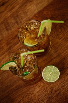 drink concept - cocktail with cola ice cubes and lime