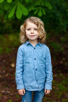Happy small child with long blond hair enjoying the nature