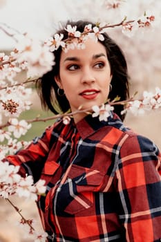 Brunette girl near a almond tree with many flowers