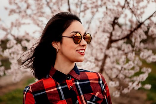 Brunette girl near a almond tree with many flowers