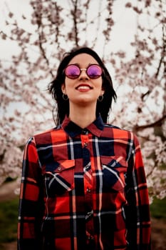 Brunette girl near a almond tree with many flowers