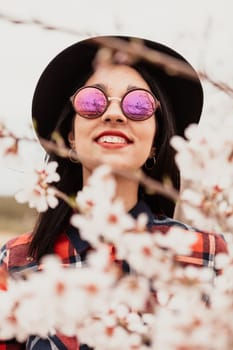 Brunette girl near a almond tree with many flowers