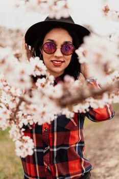 Brunette girl near a almond tree with many flowers