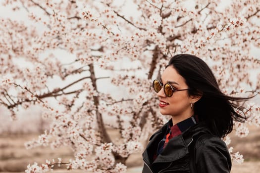 Brunette girl near a almond tree with many flowers