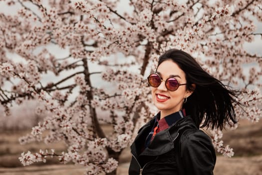 Brunette girl near a almond tree with many flowers