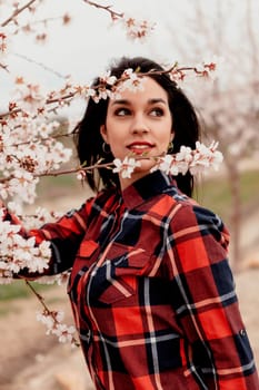 Brunette girl near a almond tree with many flowers