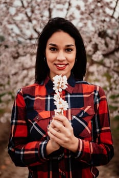 Brunette girl near a almond tree with many flowers