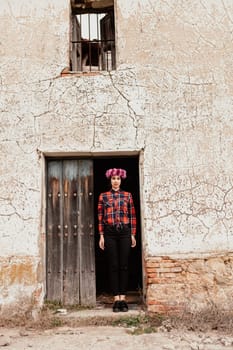 Pretty stylish girl with pink flower crown and red plaid shirt in a old house