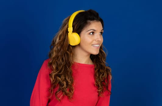 Portrait of beautiful caucasian girl with curly hair and headphones listening music isolated on a white background