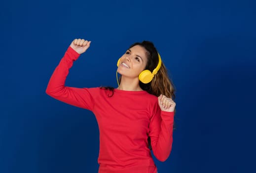 Portrait of beautiful caucasian girl with curly hair and headphones listening music isolated on a white background