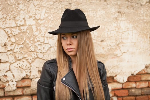 Blonde young woman with black hat and leather jacket