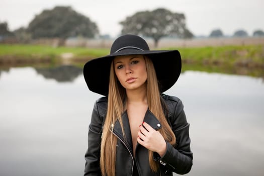 Stylish young woman with beautiful hat with a beautiful landscape of background