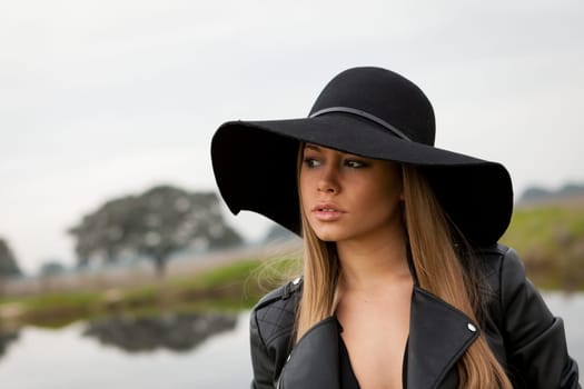 Stylish young woman with beautiful hat with a beautiful landscape of background
