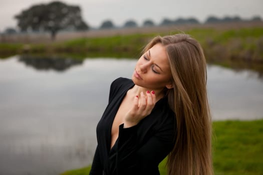 Attractive girl with long hair and sexy black shirt in the field