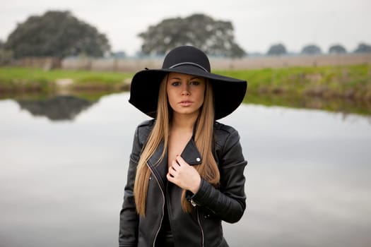 Stylish young woman with beautiful hat with a beautiful landscape of background