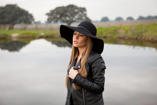 Stylish young woman with beautiful hat with a beautiful landscape of background