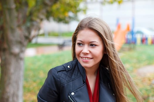 Blonde woman with leather jacket in a park
