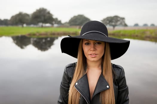 Stylish young woman with beautiful hat with a beautiful landscape of background