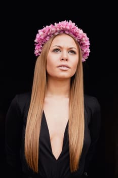 Beautiful portrait of a blonde girl with a pink crown of flowers on her head