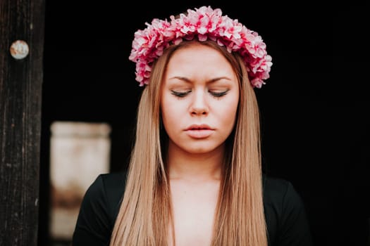 Beautiful portrait of a blonde girl with a pink wreath of flowers on her head