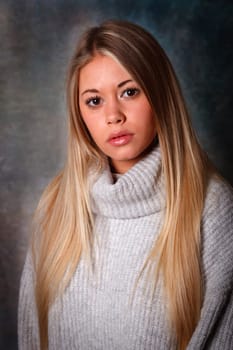 Pretty girl with long blond hair and blue background