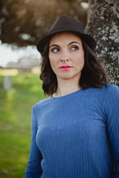Stylish young woman with black hat in the field