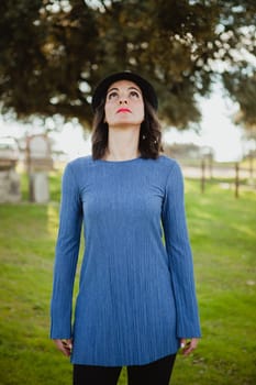 Stylish young woman with black hat in the field