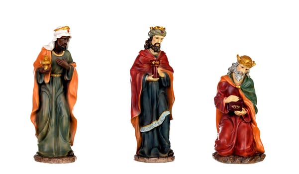 The three wise men and baby Jesus. Ceramic figures isolated on white background