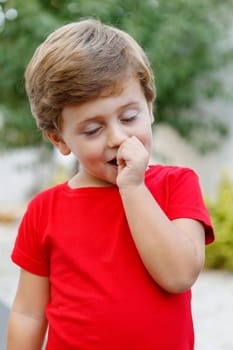 Happy child with red t-shirt playing in the garden