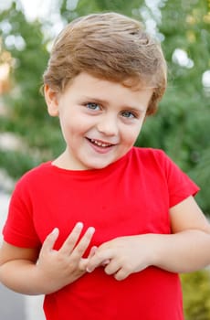 Happy child with red t-shirt playing in the garden