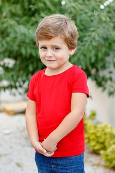 Happy child with red t-shirt playing in the garden