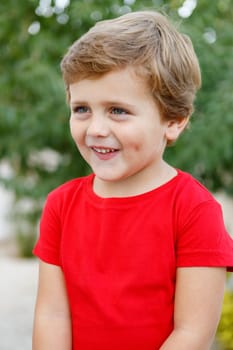 Happy child with red t-shirt playing in the garden