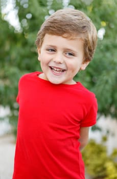 Happy child with red t-shirt playing in the garden