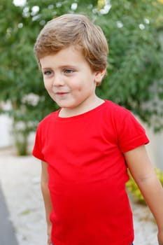 Happy child with red t-shirt playing in the garden