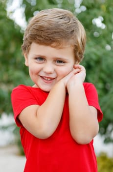 Happy child with red t-shirt playing in the garden