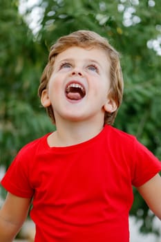 Happy child with red t-shirt playing in the garden