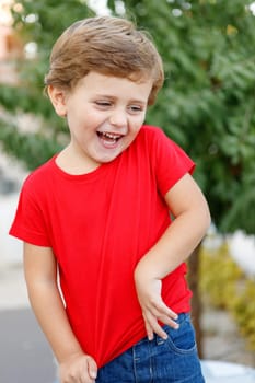 Happy child with red t-shirt playing in the garden