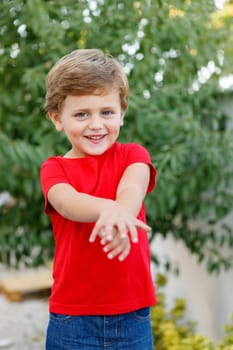 Happy child with red t-shirt playing in the garden
