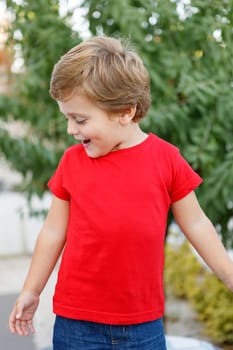 Happy child with red t-shirt playing in the garden