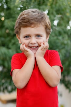 Happy child with red t-shirt playing in the garden