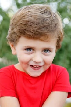 Happy child with red t-shirt playing in the garden