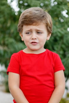 Happy child with red t-shirt playing in the garden