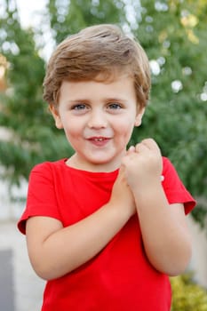 Happy child with red t-shirt playing in the garden