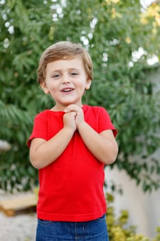 Happy child with red t-shirt playing in the garden