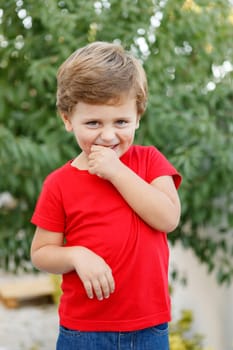 Happy child with red t-shirt playing in the garden
