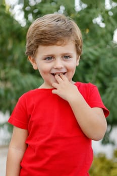 Happy child with red t-shirt playing in the garden