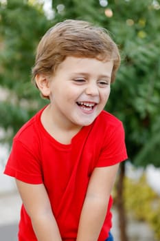 Happy child with red t-shirt playing in the garden