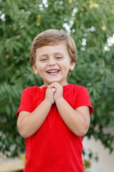 Happy child with red t-shirt playing in the garden